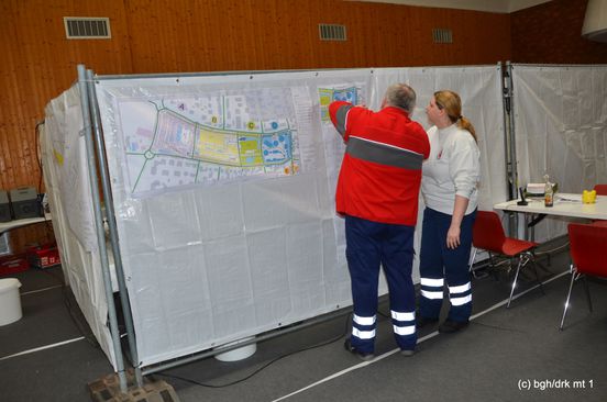 Zwei Helfer vor dem Lageplan des Marktgeländes